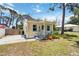 Quaint yellow cottage with a well-kept lawn, a small front porch, and a convenient parking area at 233 N New York Ave, Englewood, FL 34223