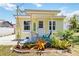Charming yellow home featuring a cozy front porch with a welcome sign and a small, landscaped garden at 233 N New York Ave, Englewood, FL 34223