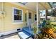 Close up of a charming front porch with welcome sign and blue painted deck, cozy seating at 233 N New York Ave, Englewood, FL 34223