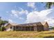 Rear view of the home with a screened-in pool and an ample yard at 238 Mark Twain Ln, Rotonda West, FL 33947