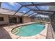 Enclosed pool with patio and metal railing to assist with pool entry at 238 Mark Twain Ln, Rotonda West, FL 33947