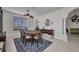 Dining room with dark wood table set, blue rug, and window with blinds in a bright, naturally lit home at 24312 Westgate Blvd, Port Charlotte, FL 33980