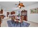 Traditional dining room with wood table set, ornate hutch, blue rug, and ceiling fan with leaf design at 24312 Westgate Blvd, Port Charlotte, FL 33980