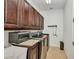Laundry room featuring modern washer and dryer, sink basin, countertop, and wood cabinetry at 24312 Westgate Blvd, Port Charlotte, FL 33980