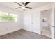 Bright bedroom with gray wood flooring and view into a kitchen with white cabinetry at 3129 Buttonwood Pl, Punta Gorda, FL 33950