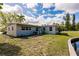 Exterior side view of a home, featuring a pond, landscaping, and an assortment of windows at 3129 Buttonwood Pl, Punta Gorda, FL 33950