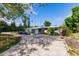 Single-story home exterior with light blue paint, a circular driveway, and tropical plants at 3129 Buttonwood Pl, Punta Gorda, FL 33950