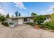 Inviting front of the home features a well-maintained yard with decorative plants and a long driveway at 3129 Buttonwood Pl, Punta Gorda, FL 33950