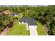 A bright single-Gathering home features an attached garage, fresh landscaping and a long driveway at 355 Milton St, Port Charlotte, FL 33954