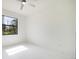 Bright bedroom featuring a ceiling fan and white marble floors, bathed in natural light from a large window at 355 Milton St, Port Charlotte, FL 33954