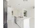 White kitchen island with stainless steel dishwasher and sink, and views to the backyard through double doors at 355 Milton St, Port Charlotte, FL 33954