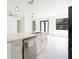 Kitchen island with stainless-steel dishwasher and sink, white marble tile flooring, and doors to the back yard at 355 Milton St, Port Charlotte, FL 33954