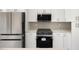 Modern kitchen featuring white cabinetry, stainless steel appliances, and an oven with black cooktop and microwave hood at 355 Milton St, Port Charlotte, FL 33954