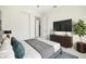 Comfortable main bedroom boasts a bed, wooden dresser with TV, and a lush potted plant at 355 Milton St, Port Charlotte, FL 33954