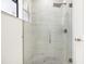 Modern shower stall featuring a marble tile surround, rainfall shower head, and glass door at 355 Milton St, Port Charlotte, FL 33954