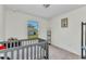 Bright Bedroom features a grey crib and a view to the backyard at 3799 Laredo Ave, North Port, FL 34288