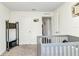Bright Bedroom features a grey crib and views to the hallway and backyard at 3799 Laredo Ave, North Port, FL 34288