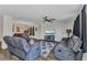 Spacious living room featuring comfortable seating, a ceiling fan, a modern TV, and wood-look floors at 3799 Laredo Ave, North Port, FL 34288