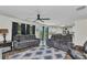 Open-concept living room featuring modern sofas, ceiling fan, and sliding glass door leading to the outside at 3799 Laredo Ave, North Port, FL 34288