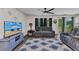 Inviting living room with plush seating, a ceiling fan, a TV, and a bright, patterned rug on wood-look floors at 3799 Laredo Ave, North Port, FL 34288
