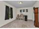 Cozy office space featuring plush carpeting, a window with dark curtains, and an antique grandfather clock at 3799 Laredo Ave, North Port, FL 34288