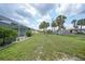 Lush backyard with mature palm trees surrounds a screened-in pool area, offering privacy and outdoor enjoyment at 4055 Alwick Ln, North Port, FL 34287