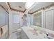 Bright bathroom features a floral border, shower with glass door, and a white vanity with large mirror at 4055 Alwick Ln, North Port, FL 34287