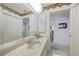 Bathroom view features a large mirror, white vanity, tiled floor, and a hallway leading to other rooms at 4055 Alwick Ln, North Port, FL 34287