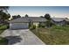 A single-story house with a large driveway, two-car garage and tropical landscaping at dusk at 4055 Alwick Ln, North Port, FL 34287