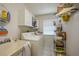 Functional laundry room with sink, washer, dryer, storage cabinets, and shelves for organization at 4055 Alwick Ln, North Port, FL 34287