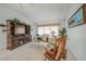 Comfortable living room with carpet flooring, a large entertainment center, and plenty of natural light at 4055 Alwick Ln, North Port, FL 34287