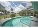 A serene in-ground pool with a screened enclosure, surrounded by tropical plants, offers a private oasis at 4055 Alwick Ln, North Port, FL 34287