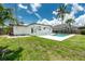 Spacious backyard features a pristine pool, lush lawn, and tropical foliage for outdoor enjoyment at 416 Allen St, Punta Gorda, FL 33950