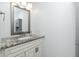 Bright bathroom featuring a granite countertop, mirror, and modern lighting at 416 Allen St, Punta Gorda, FL 33950