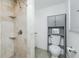 Bathroom features a travertine tile walk-in shower with rainfall shower head and a modern toilet at 416 Allen St, Punta Gorda, FL 33950