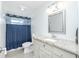 Bathroom featuring blue shower curtain, granite countertop and updated cabinets at 416 Allen St, Punta Gorda, FL 33950