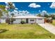 Charming single story home with metal roof, green lawn, and mature landscaping at 416 Allen St, Punta Gorda, FL 33950
