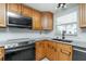 Features wooden cabinetry, granite countertops, and modern black appliances including oven and microwave at 416 Allen St, Punta Gorda, FL 33950