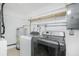 Bright laundry room with washer, dryer, water heater, and storage shelf for convenience at 416 Allen St, Punta Gorda, FL 33950