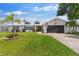 Charming single-story home featuring a well-manicured lawn, brick driveway, and a two-car garage at 425 Corrientes Cir, Punta Gorda, FL 33983