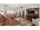 Open-concept living room with hardwood floors, a leather sectional, media cabinet and sliding doors to the lanai at 425 Corrientes Cir, Punta Gorda, FL 33983