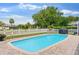 Sparkling swimming pool in a well-maintained yard with white picket fence and lush green landscaping at 425 Corrientes Cir, Punta Gorda, FL 33983