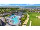 Aerial view featuring a resort-style pool and clubhouse alongside the lush green fairway of a golf course at 43406 Boardwalk Loop, Punta Gorda, FL 33982