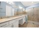 Bathroom featuring a double vanity with granite countertop and a glass-enclosed tiled shower at 43406 Boardwalk Loop, Punta Gorda, FL 33982