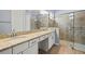 Bathroom featuring double sinks, granite countertops, and tiled glass shower at 43406 Boardwalk Loop, Punta Gorda, FL 33982