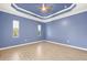 Spacious bedroom featuring tray ceiling, a ceiling fan, and wood-look tile flooring at 43406 Boardwalk Loop, Punta Gorda, FL 33982