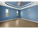 Bedroom with stylish tray ceiling, ceiling fan, wood look tile floors, and natural light at 43406 Boardwalk Loop, Punta Gorda, FL 33982