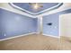A spacious bedroom featuring tray ceiling, a ceiling fan, and wood-look tile flooring at 43406 Boardwalk Loop, Punta Gorda, FL 33982