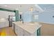 Open kitchen featuring a center island with sink, white cabinets, stainless steel appliances, and tile floors at 43406 Boardwalk Loop, Punta Gorda, FL 33982