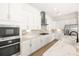 Well-equipped kitchen with white cabinetry, stainless appliances, stylish backsplash, and plenty of counter space at 43406 Boardwalk Loop, Punta Gorda, FL 33982